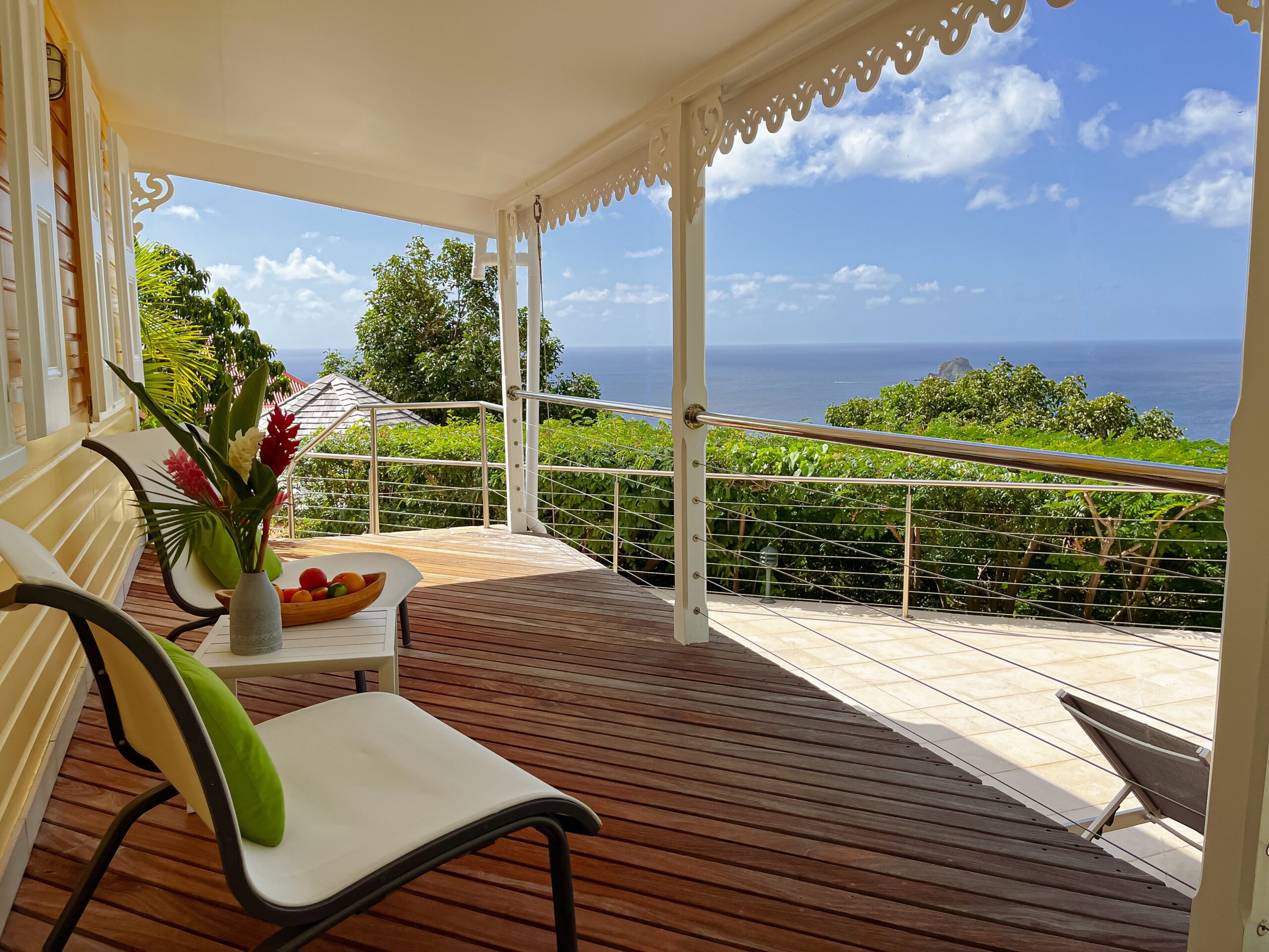 Ocean-view terrace at St Barts villa with tropical flowers and seating area