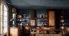 Rustic villa kitchen with wicker cabinetry, wooden dining table, and blue walls in St Barts vacation rental