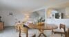Bright open-plan living and dining area with wooden furniture and fruit centerpiece in a St Barts villa rental.