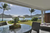 Waterfront terrace with fruit bowl on glass table, sun loungers, and panoramic sea views at a luxury villa in St Barts.