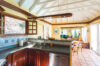 Open kitchen at St Barts villa with stone counters, wooden cabinets, and view to dining room