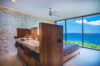 Contemporary bedroom in a St Barts villa with floor-to-ceiling windows and panoramic ocean views