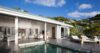 Elegant villa with infinity pool, sun loungers, and open living spaces set against lush hills in St Barts vacation rental.