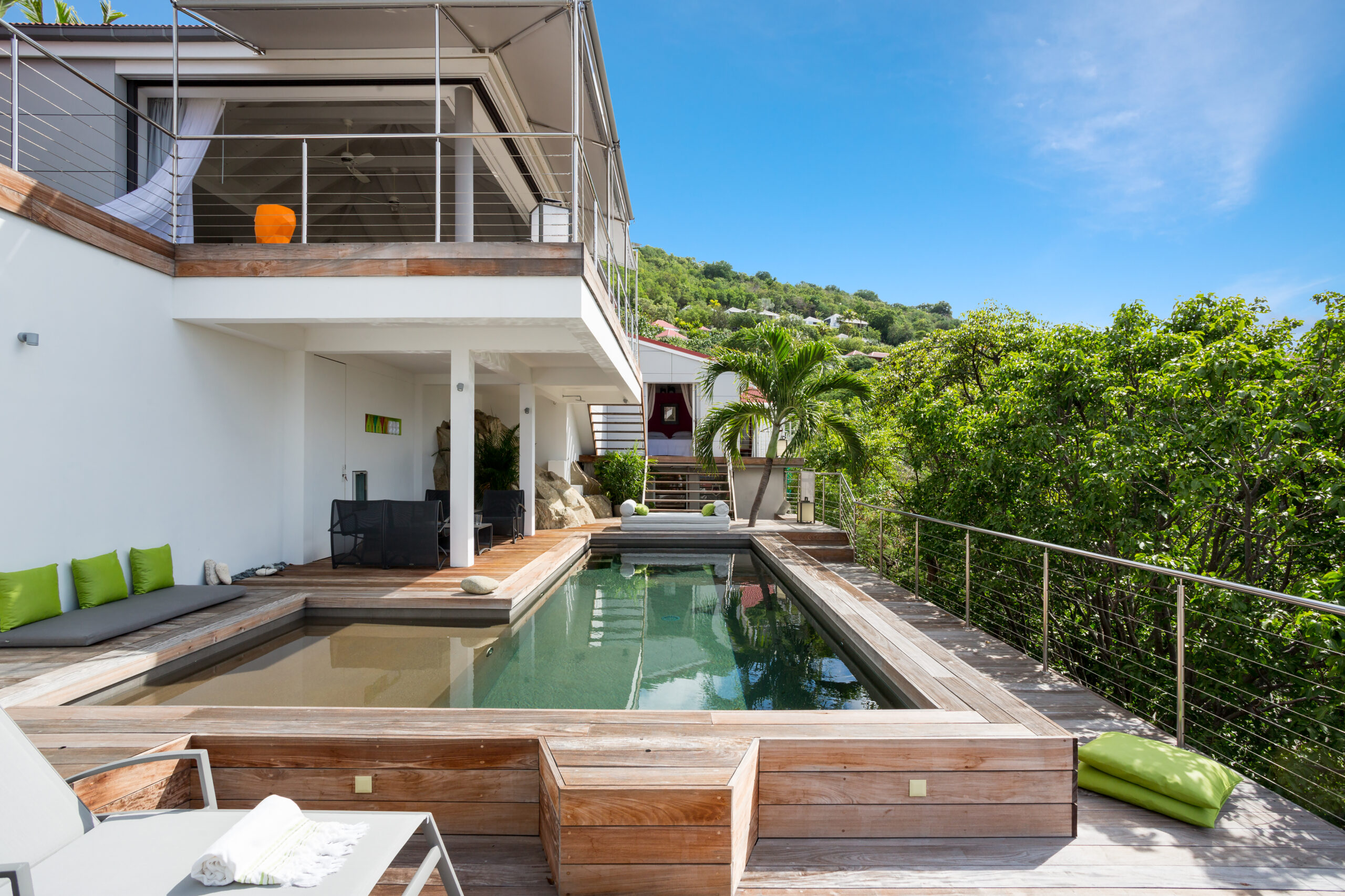 Sunbathing area beside a serene pool, furnished with comfortable loungers and offering a beautiful view of the surrounding landscape