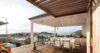 Elegant lounge area on a wooden deck, furnished with modern outdoor seating, overlooking a panoramic view of the surrounding landscape.