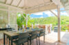 Covered outdoor dining area at St Barts villa with hillside views and elegant table setting