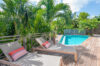 Private villa pool with sun loungers surrounded by tropical palm trees in St Barts