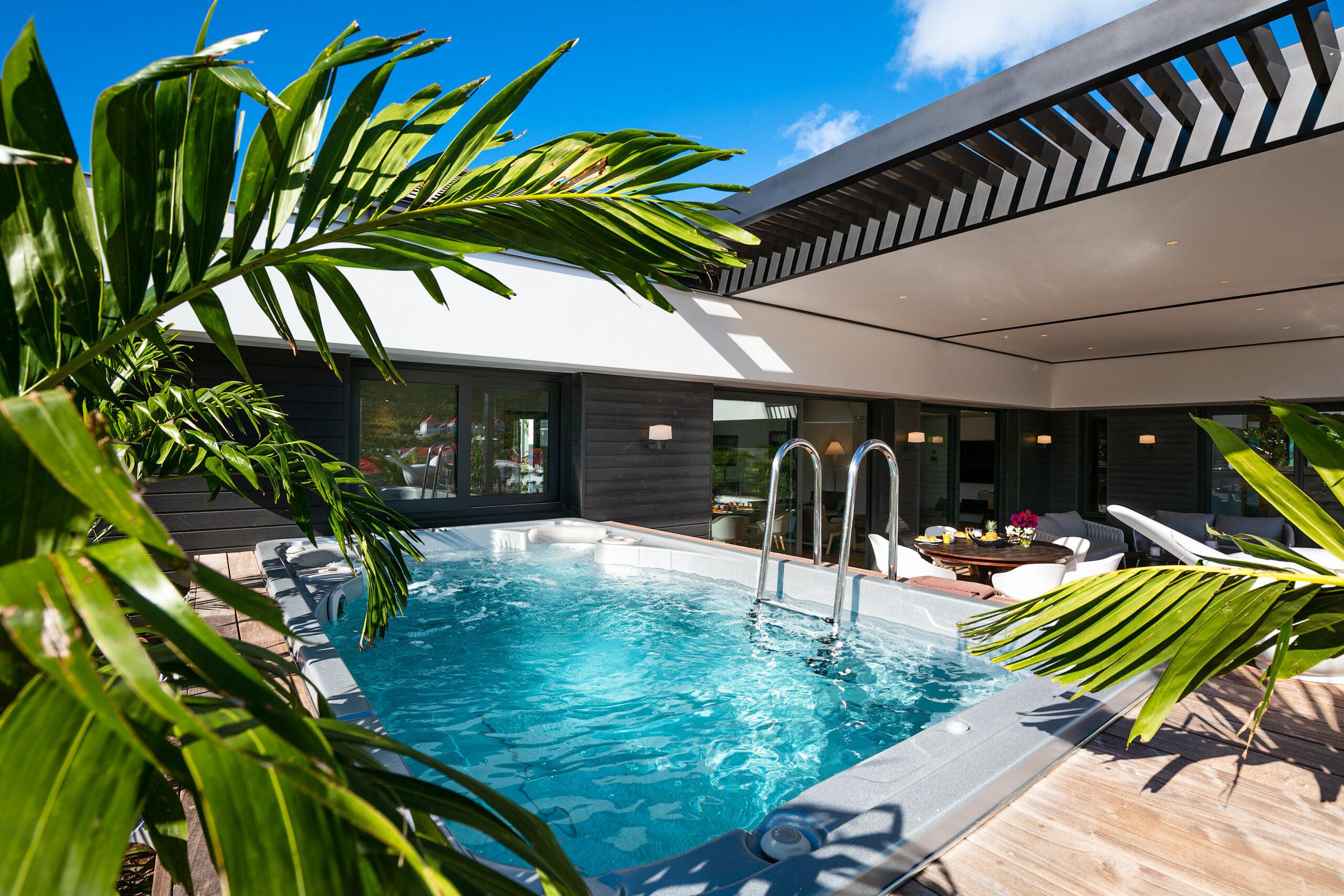 Sunbathing area next to a calm pool, equipped with cozy loungers and overlooking a stunning natural landscape