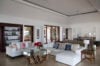 Spacious living room with white sofas, glass coffee table, and built-in bookshelves at a luxury St Barts villa