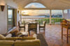 Terrace dining area at a St Barts luxury villa overlooking the ocean at sunset.
