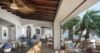 Covered outdoor lounge with vaulted wooden beams and ocean views at a luxury villa in St Barts.