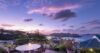 Evening view of a St Barts villa terrace with glowing pool and serene ocean backdrop.