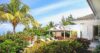 Spacious open-plan kitchen and living area in a St Barts villa with sleek black countertops, dining space, and ocean-view terrace access.