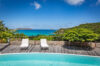 Curved infinity pool at a St Barts villa rental with sun loungers and turquoise sea views.