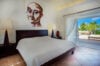 Bedroom with contemporary artwork, terrace access, and garden view at St Barthelemy vacation rental