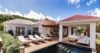 Spacious villa terrace with sun loungers, shaded lounge, and private pool beside white pavilions in St Barts vacation rental.