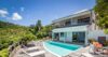 Modern hillside villa in St Barts with infinity-edge pool, sun loungers, and lush tropical views.