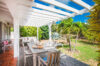 Villa terrace with white pergola, wooden dining table, and garden views in St Barts private villa rental.