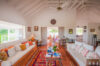 Colorful villa living room with white sofas, vibrant cushions, and terracotta tile floors in St Barts vacation rental.
