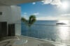 Terrace of St Barts villa with glass railing, lounge chairs, and panoramic Caribbean Sea view