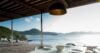 Covered outdoor dining area with modern tableware overlooking the Caribbean Sea and green hills in St Barts.