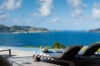 Elegant loungers arranged on a wooden deck, overlooking the turquoise Caribbean Sea.