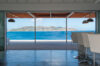 Dining area with bar stools opening to terrace and panoramic sea views in a modern St Barts villa