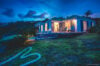 Modern villa glowing at dusk with open terraces, lounge chairs, and hillside views in a St Barts vacation rental.