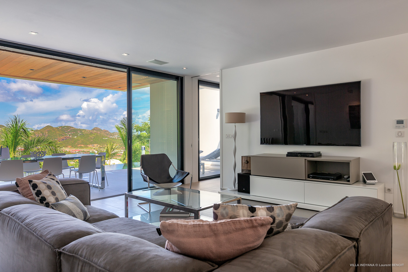 Modern living room in St Barts vacation rentals with large TV and terrace access