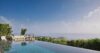 Infinity pool at a St Barts villa with lounge seating and panoramic views of the Caribbean Sea and green hillsides.