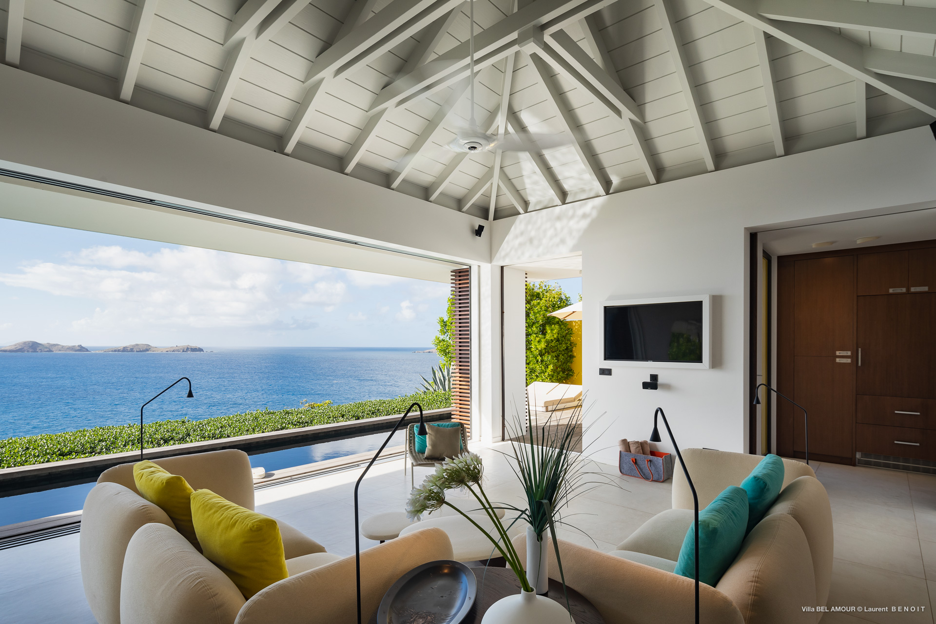 Open-plan living room with colorful seating and panoramic sea view at luxury villa in St Barts