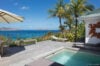 Plunge pool with wooden deck, palm trees, and sweeping ocean views in a luxury St Barts villa rental.