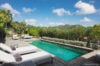 Private villa pool with stone deck, sun loungers, and lush garden views in St Barts luxury vacation rental.