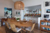 Stylish dining area with wicker chairs, wooden table, and colorful tiled kitchen in St Barts villa rental.
