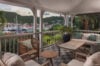 Covered terrace with wicker seating and marina views in St Barts villa rental.
