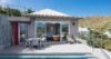 Poolside terrace of a St Barts villa with outdoor dining, sun loungers and bedroom opening to the view