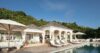 Sun loungers beside a villa with open spaces designed to create memorable experiences.