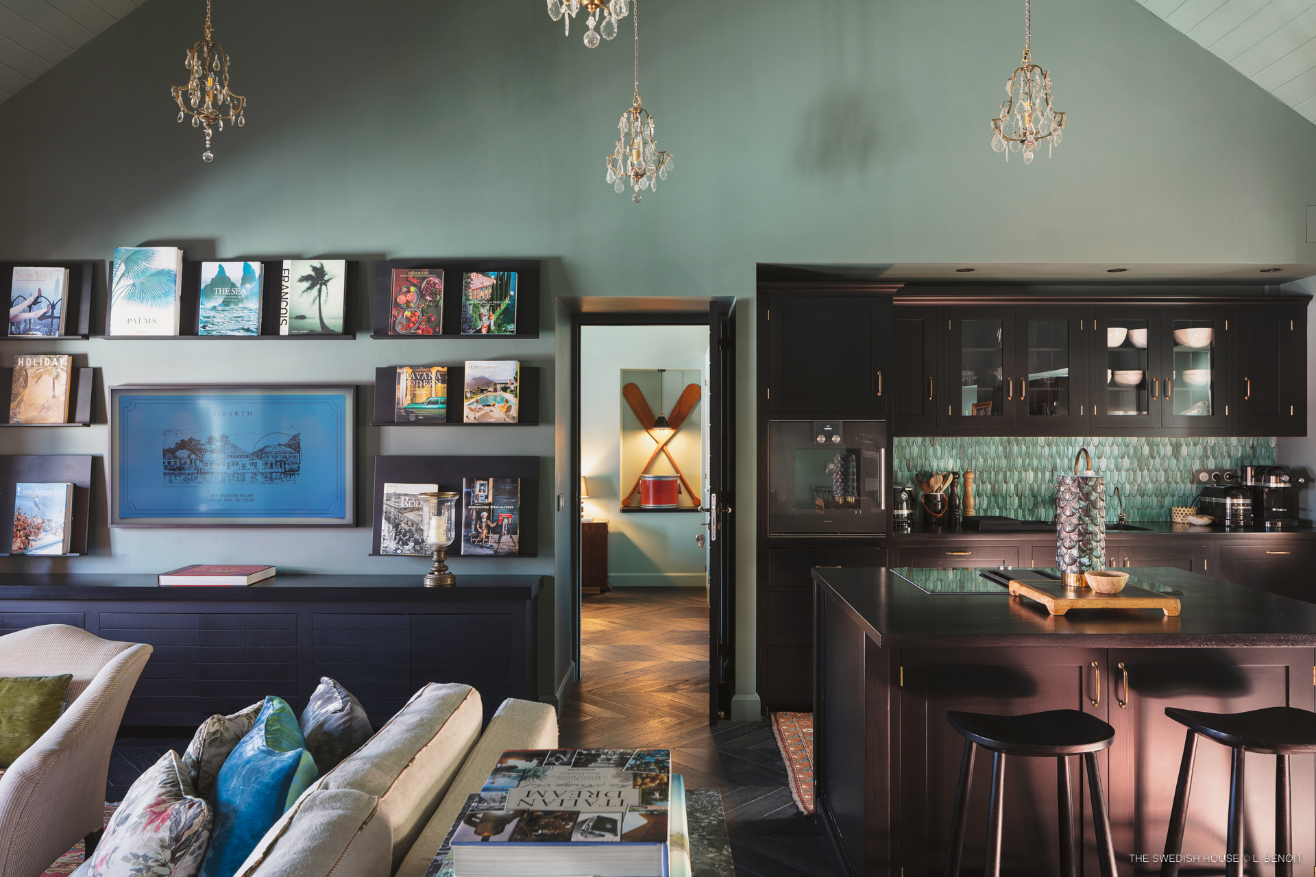 Stylish living room with art-filled walls and modern kitchen in luxury villa rental St Barts