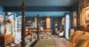 Colorful villa bedroom with four-poster bed, patterned textiles, and open-plan layout extending to dining area in St Barts rental