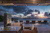 Sunset terrace at St Barts villa with wicker lounge seating and infinity pool view