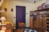 Vintage dressing room at St Barts villa with wooden wardrobe, desk, and purple door