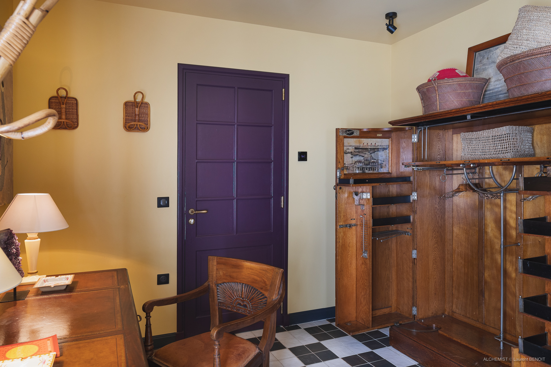 Vintage dressing room at St Barts villa with wooden wardrobe, desk, and purple door