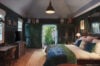Inviting bedroom with dark green walls, writing desk and garden access in St Barts vacation rental