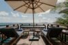 Oceanfront deck with sun loungers and umbrella overlooking the Caribbean at a private villa in St Barts.