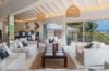 Bright living room in a St Barts villa with white sofas, natural accents and sliding doors to the terrace