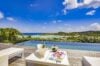 Infinity pool terrace with champagne and desserts overlooking turquoise waters in a luxury St Barts villa rental.
