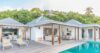 Charming St Barts villa with open-air living spaces, wooden deck, and private pool surrounded by lush greenery.
