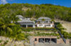 Front exterior view of Villa Jocapana with multiple terraces, tropical gardens, and hillside setting.