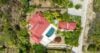 Aerial view of private villa in St Barts with red rooftops, pool, and tropical gardens