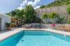 Inviting pool with sun loungers, tropical plants, and hillside backdrop in a St Barts vacation rental villa.